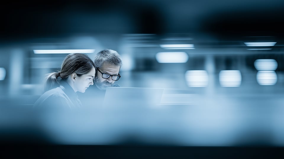 Co-workers collaborating and sharing expertise at a computer.